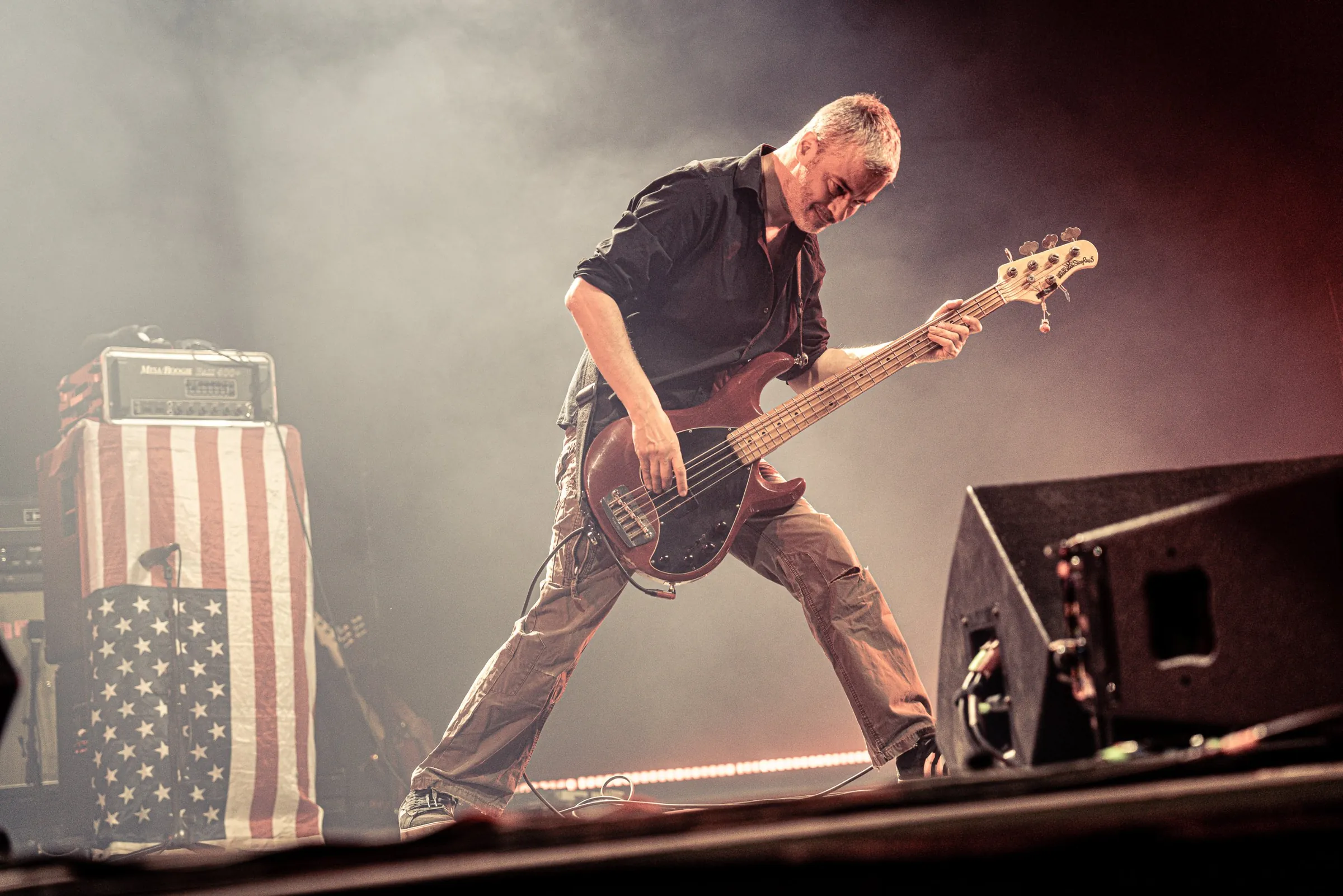 Bassist next to an amp draped in a flag